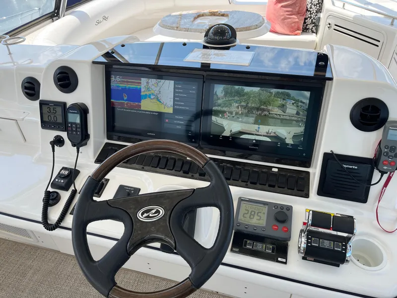 Slide: The Image of Control panel of a 2008 Sea Ray 58 Sedan yacht with navigation screens and steering wheel. - 23