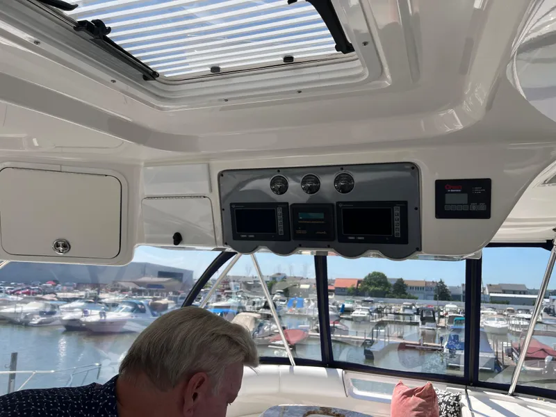 Slide: The Image of Interior view of 2008 Sea Ray 58 Sedan yacht with control panel and marina background. - 24