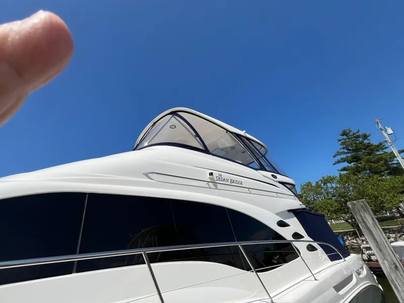Slide: The Image of 2008 Sea Ray 58 Sedan yacht against clear blue sky, docked near trees. - 3