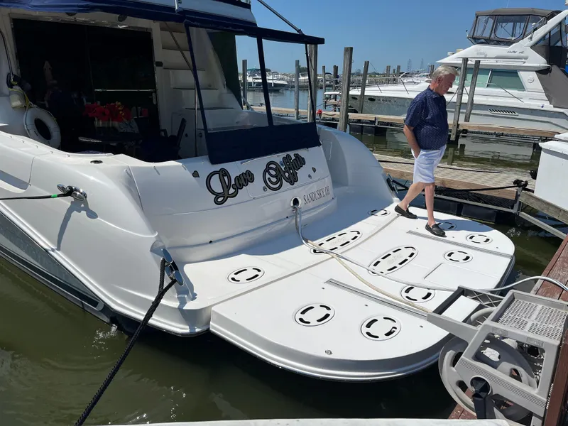 Slide: The Image of 2008 Sea Ray 58 Sedan yacht docked, man walking on deck, sunny marina setting. - 8