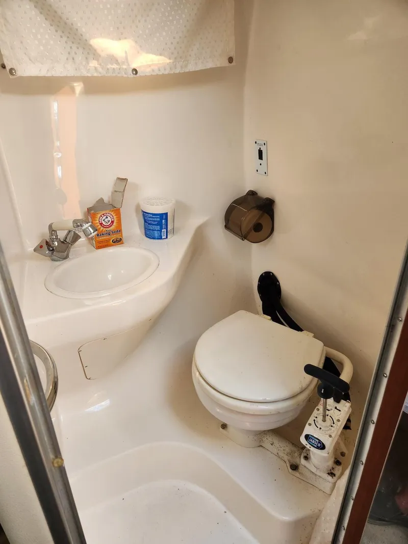 Slide: The Image of Compact bathroom in 2004 Chaparral Signature 240 boat with toilet, sink, and toiletries. - 11