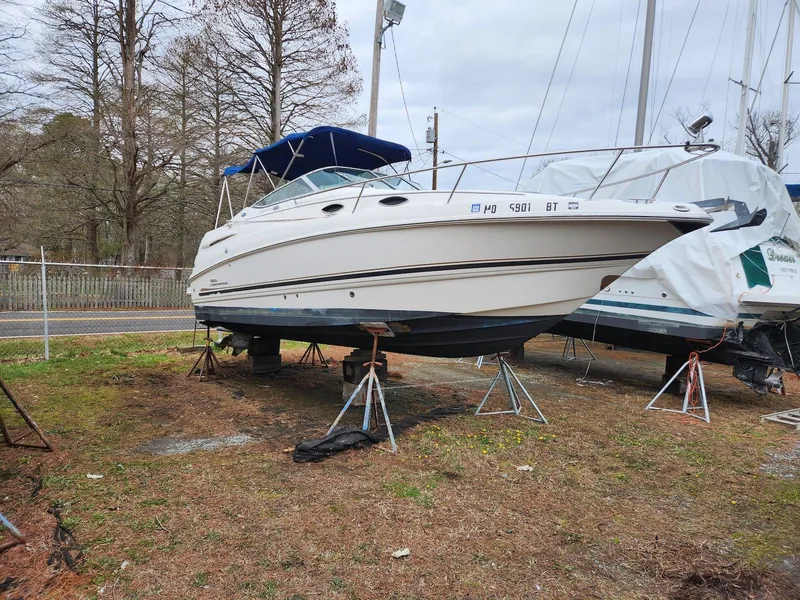 Slide: The Image of 2004 Chaparral Signature 240 boat on stands, outdoors, with trees in the background. - 2