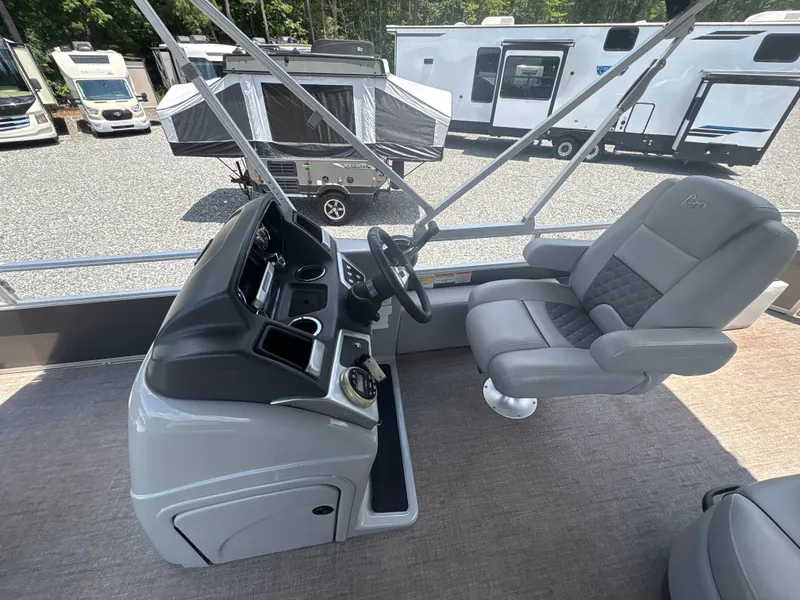 Slide: The Image of Captain's chair and console of 2021 Ranger Reata 220F boat, with RVs in background. - 12