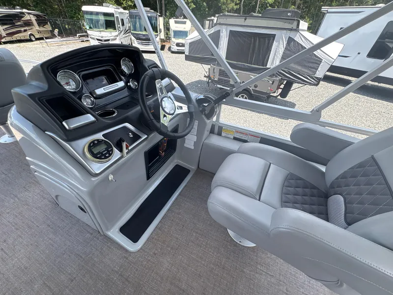 Slide: The Image of Captain's helm of 2021 Ranger Reata 220F boat with modern controls and comfortable seating. - 16
