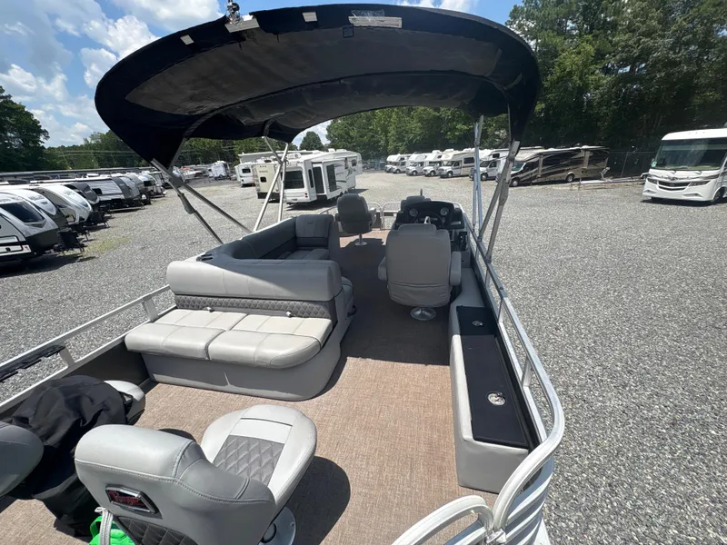 Slide: The Image of 2021 Ranger Reata 220F pontoon boat with canopy, parked in RV lot. - 6