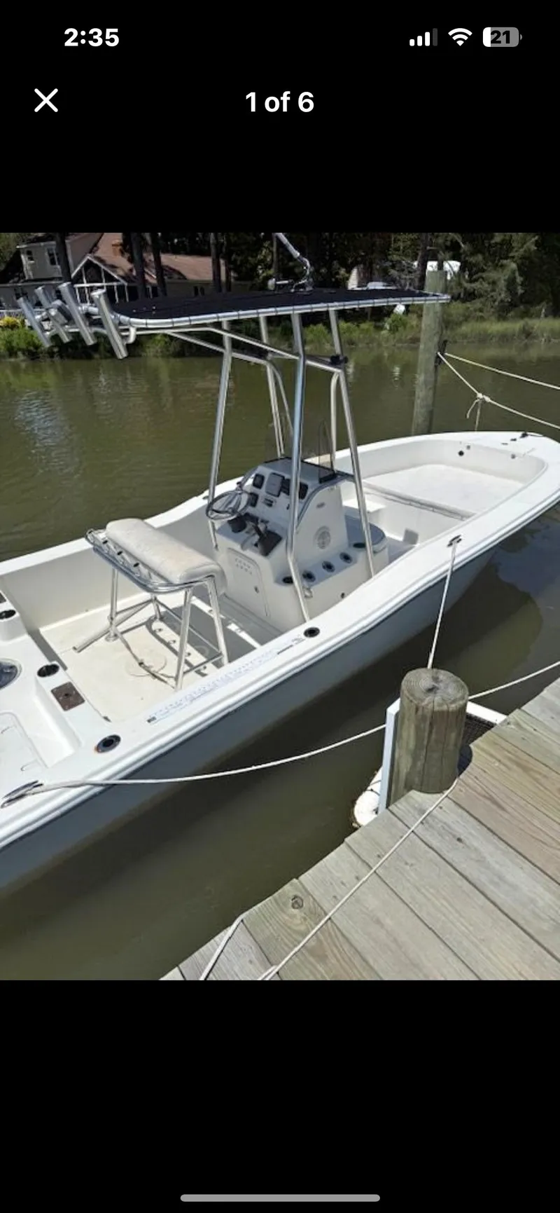 Slide: The Image of 2012 Sundance NX 21 boat docked on calm water, featuring a sleek design and open deck. - 4