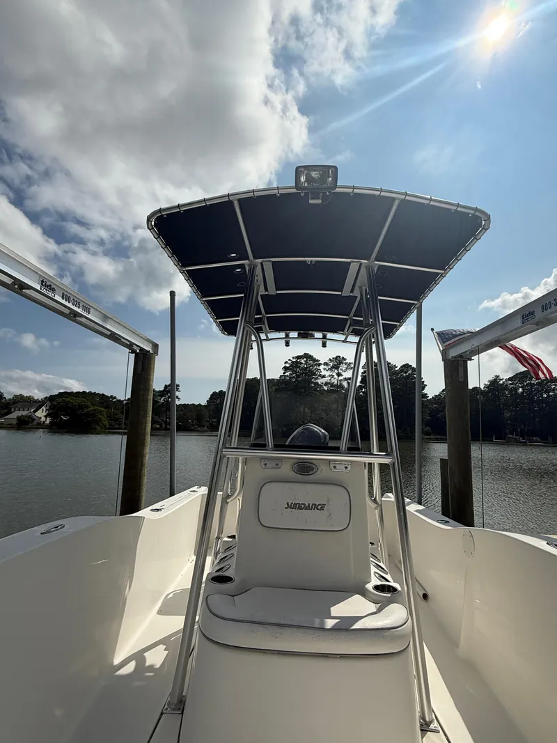 Slide: The Image of 2012 Sundance NX 21 boat docked under a sunny sky. - 5
