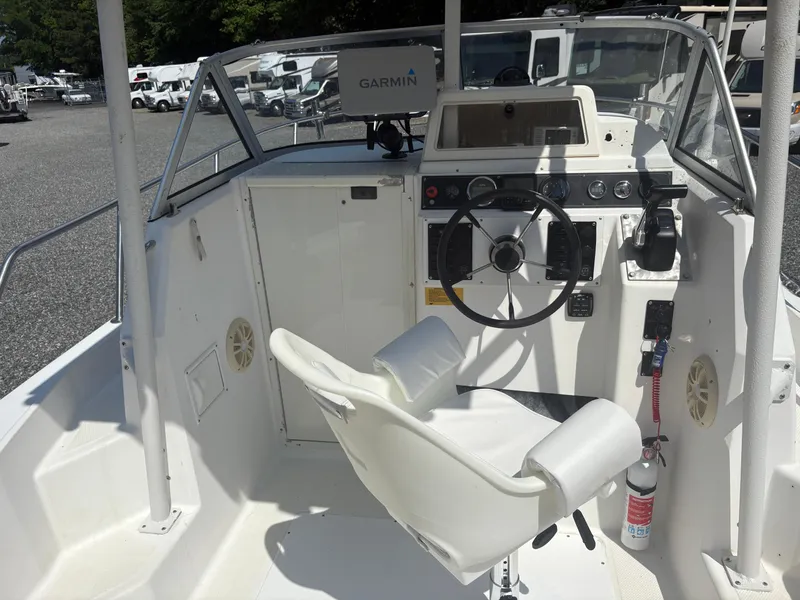 Slide: The Image of Key West 2300 Bluewater boat cockpit with steering wheel and Garmin navigation system, 2000 model. - 13