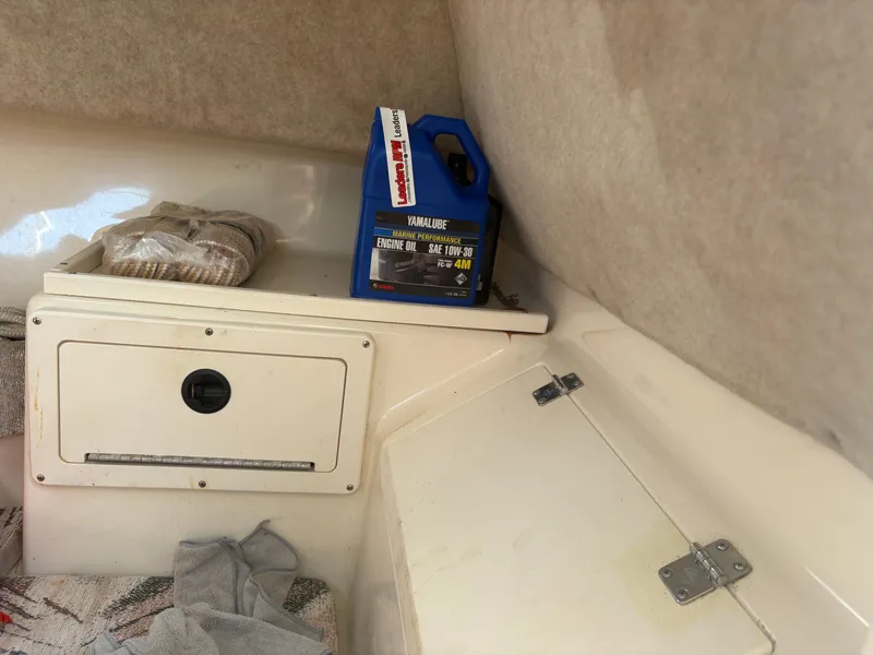 Slide: The Image of Interior of 2000 Key West 2300 Bluewater with engine oil container and storage compartments. - 20