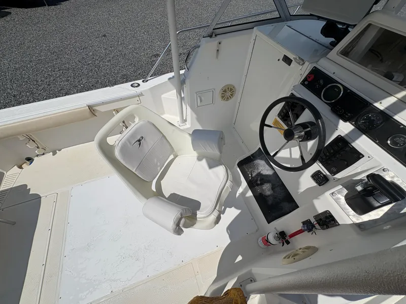 Slide: The Image of Interior view of a 2000 Key West 2300 Bluewater boat cockpit with steering wheel and seating. - 23