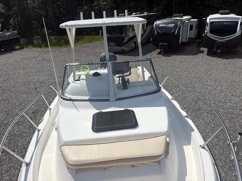 Slide: The Image of Key West 2300 Bluewater boat, 2000 model, parked near RVs on gravel lot. - 24