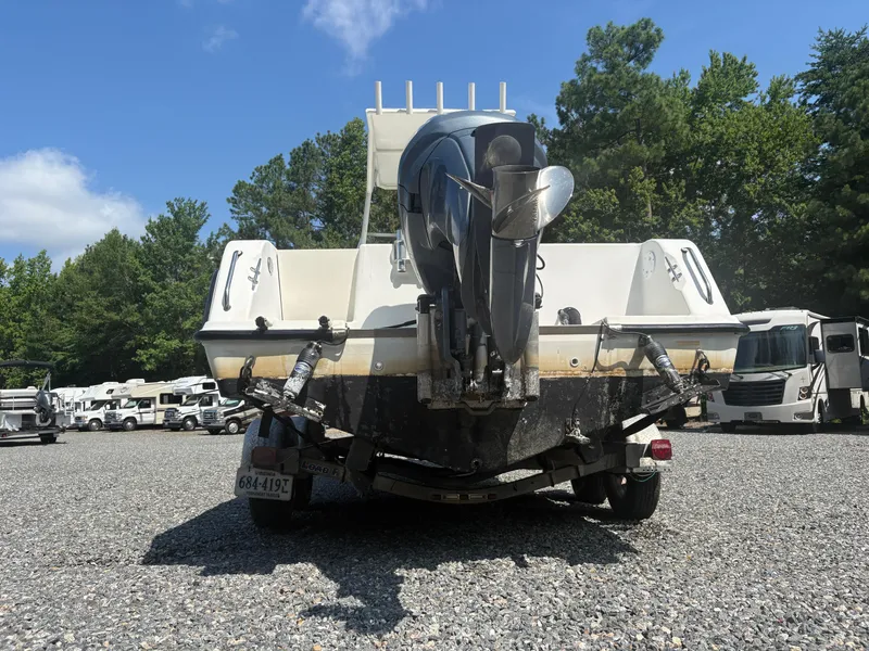 Slide: The Image of 2000 Key West 2300 Bluewater boat on trailer, parked outdoors with trees and RVs. - 3