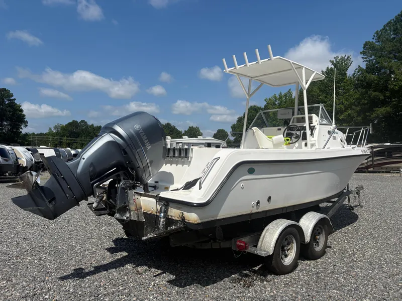 Slide: The Image of 2000 Key West 2300 Bluewater boat on trailer with Yamaha outboard motor, parked outdoors. - 4