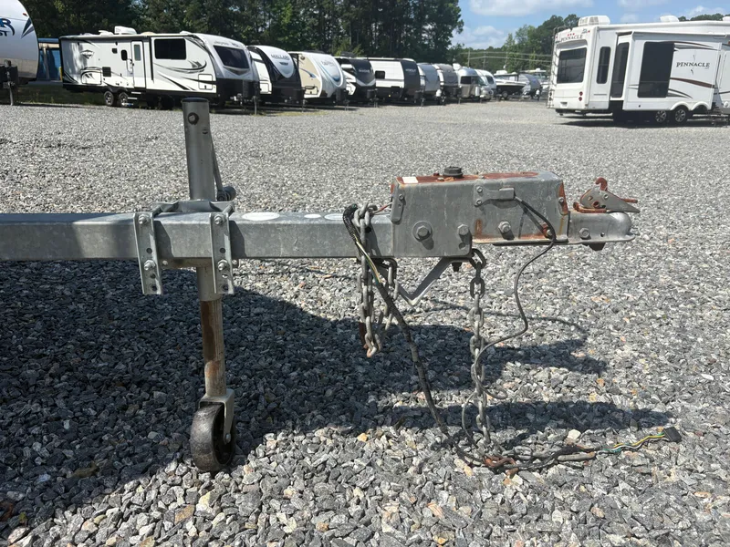 Slide: The Image of Trailer hitch on gravel lot with RVs in background, Key West 2300 Bluewater, 2000 model. - 6