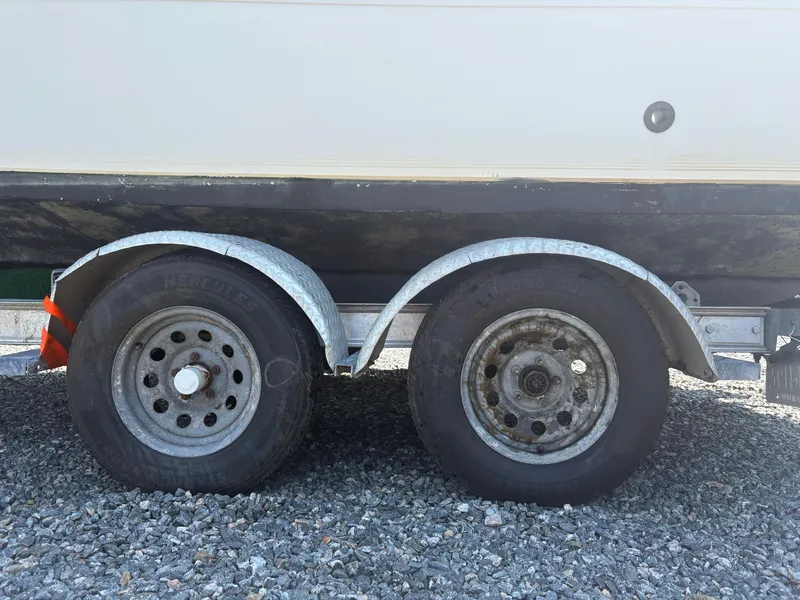 Slide: The Image of Trailer wheels of a 2000 Key West 2300 Bluewater boat on gravel surface. - 8