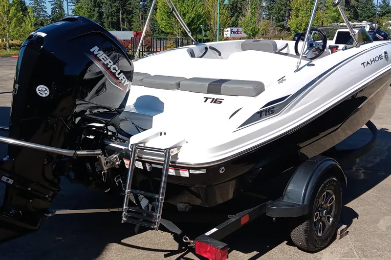 Slide: The Image of 2025 Tahoe T16 boat with Mercury engine on trailer, parked outdoors. - 2