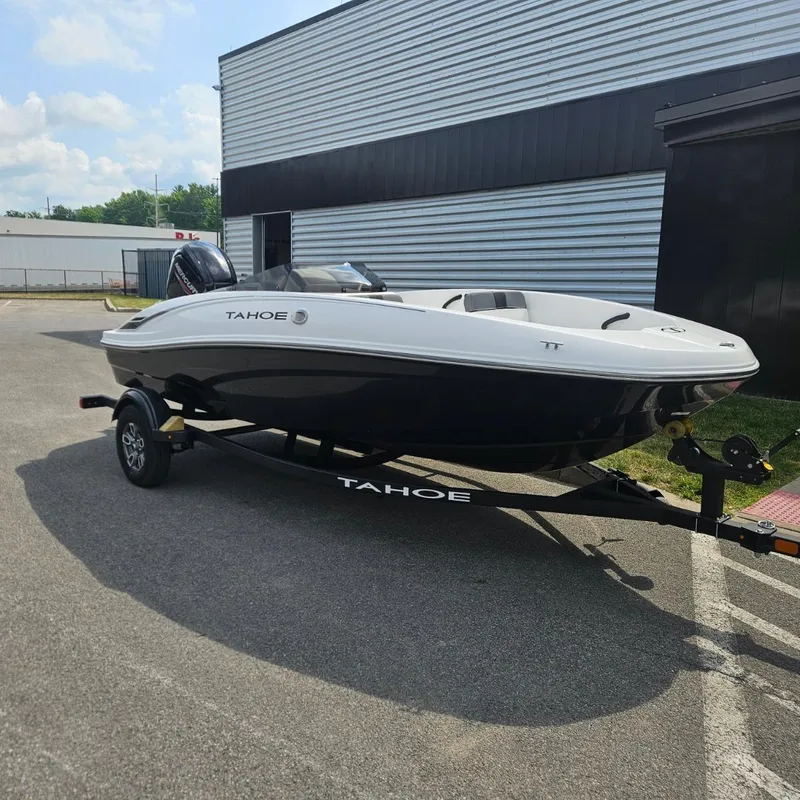 The Image of 2025 Tahoe T16 boat on trailer, parked outdoors near a building. - 0