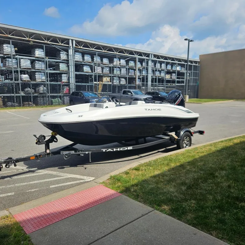 Slide: The Image of 2025 Tahoe T16 boat on trailer in parking lot, sunny day. - 1