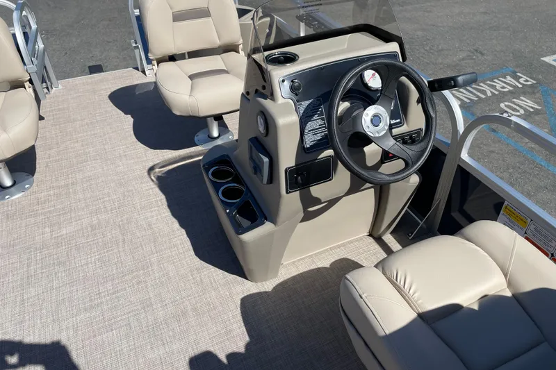 Slide: The Image of 2025 Sun Tracker Bass Buggy 18 DLX interior with steering console and beige seating. - 7