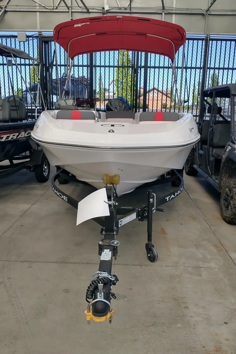 The Image of 2025 Tahoe T16 boat with red canopy on trailer in showroom. - 0