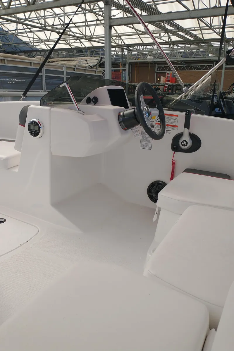 Slide: The Image of 2025 Tahoe T16 boat interior with steering wheel and seating in a showroom. - 5