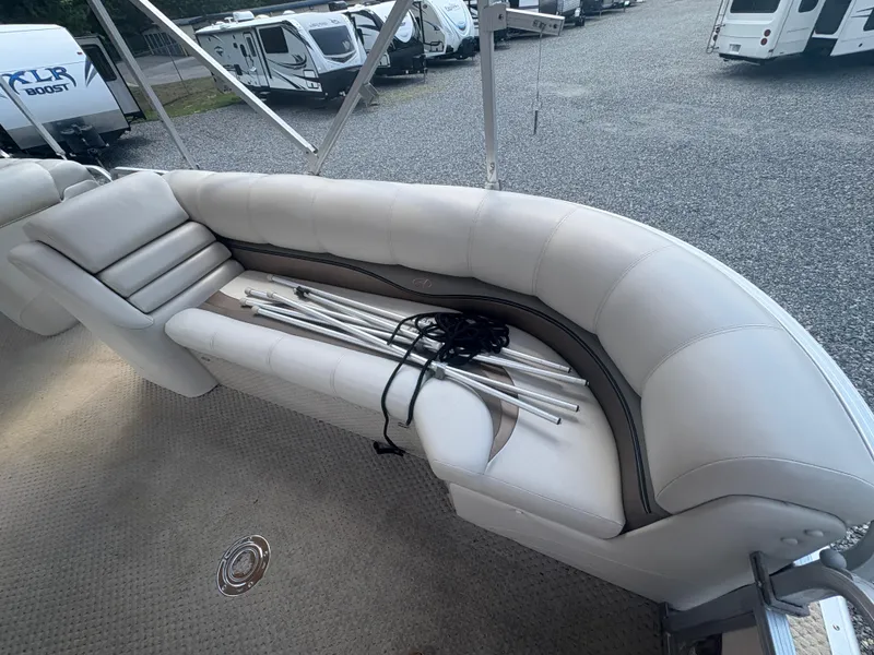 Slide: The Image of 2009 Avalon Paradise 24' boat interior with white seating and metal poles. - 18