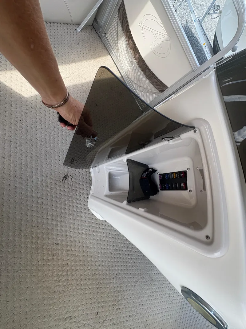 Slide: The Image of 2009 Avalon Paradise 24' boat interior with open storage compartment and visible control panel. - 20