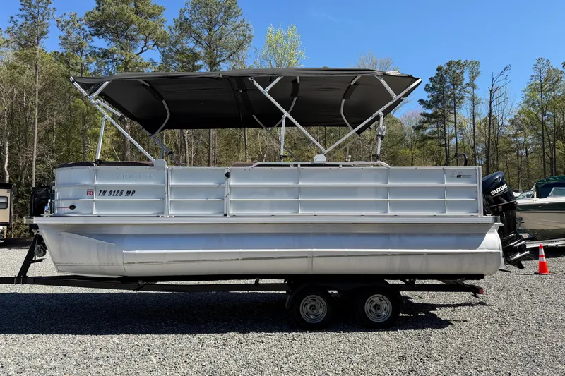 Slide: The Image of 2021 Lexington 321 pontoon boat with canopy on a trailer, parked outdoors. - 22