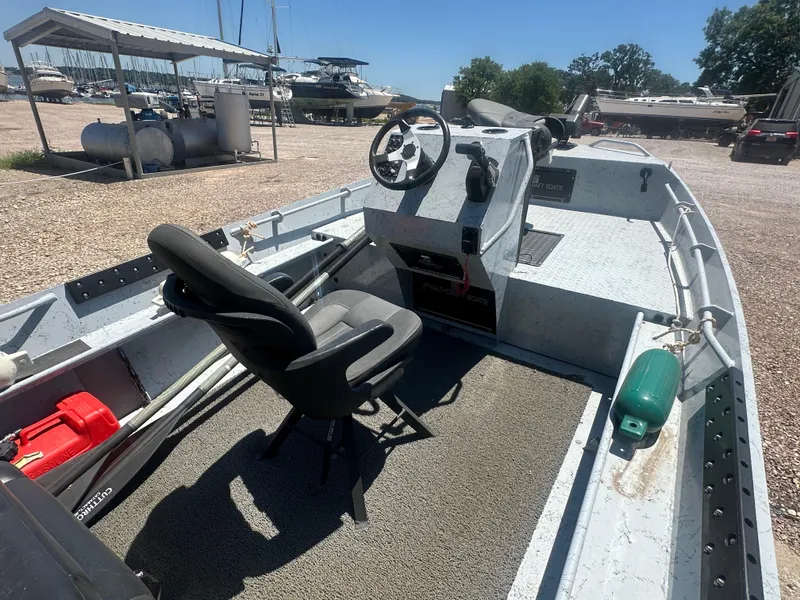 Slide: The Image of 2023 StealthCraft Stealthweld 18 boat interior with steering console and seating at marina. - 17