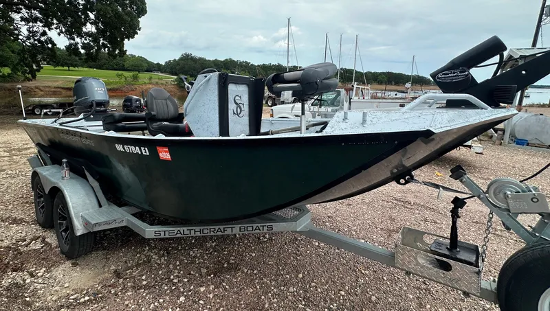 Slide: The Image of 2023 StealthCraft Stealthweld 18 boat on trailer, parked near marina. - 6