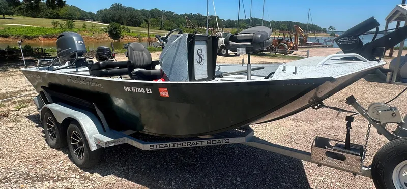 Slide: The Image of 2023 StealthCraft Stealthweld 18 boat on trailer, parked near a lake. - 7