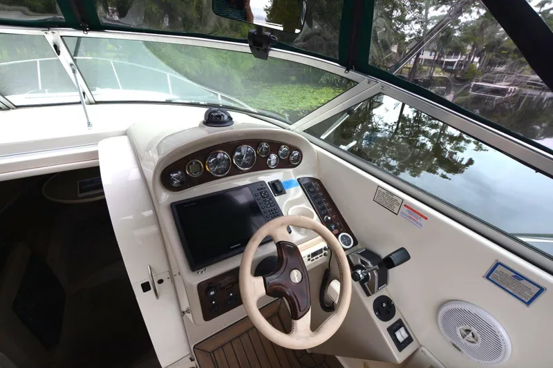 Slide: The Image of 1999 Rinker 270 Fiesta Vee boat helm with steering wheel and control panel. - 10