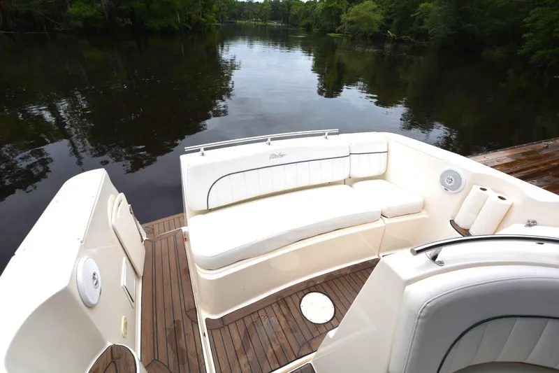Slide: The Image of 1999 Rinker 270 Fiesta Vee boat interior with white seating and wooden deck. - 11