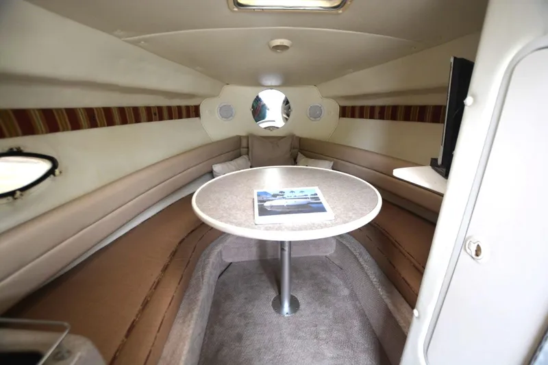 Slide: The Image of 1999 Rinker 270 Fiesta Vee cabin interior with table and seating area. - 12