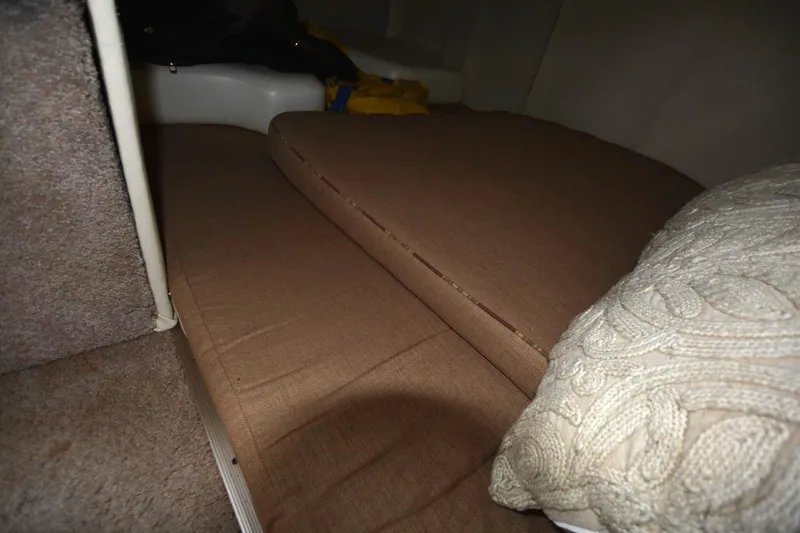 Slide: The Image of Interior cabin of 1999 Rinker 270 Fiesta Vee with brown cushions and a knitted pillow. - 16
