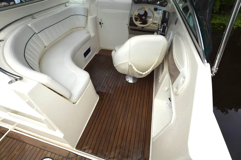Slide: The Image of 1999 Rinker 270 Fiesta Vee boat interior with white seating and wooden flooring. - 9