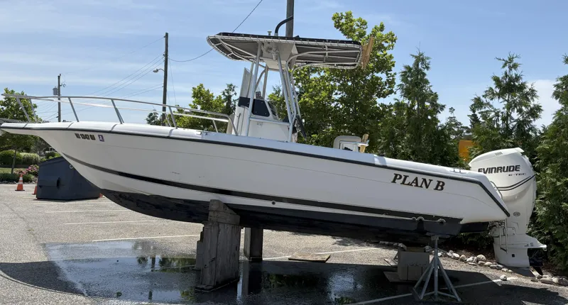 The Image of 1999 Century 2300 Center Console boat on stand, named "Plan B," with Evinrude engine. - 0