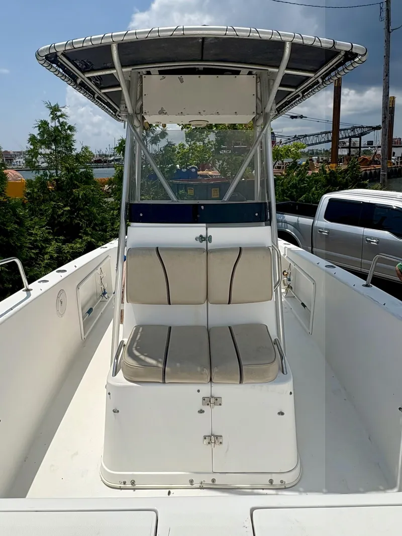 Slide: The Image of 1999 Century 2300 Center Console boat with seating and canopy, docked outdoors. - 11