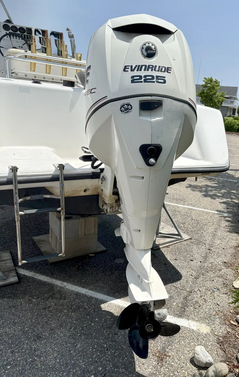 Slide: The Image of 1999 Century 2300 Center Console with Evinrude 225 outboard motor in parking lot. - 2