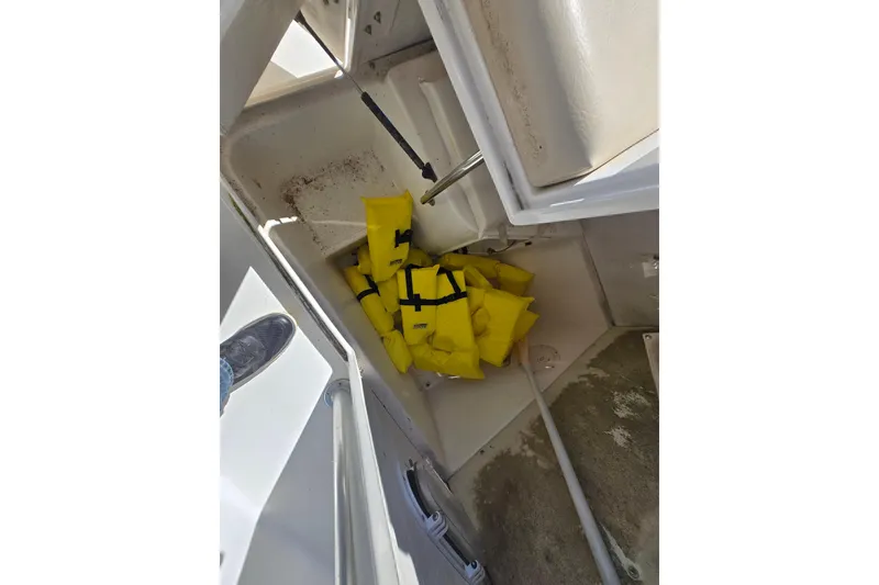 Slide: The Image of Storage compartment with yellow life jackets on a 1999 Century 2300 Center Console boat. - 22