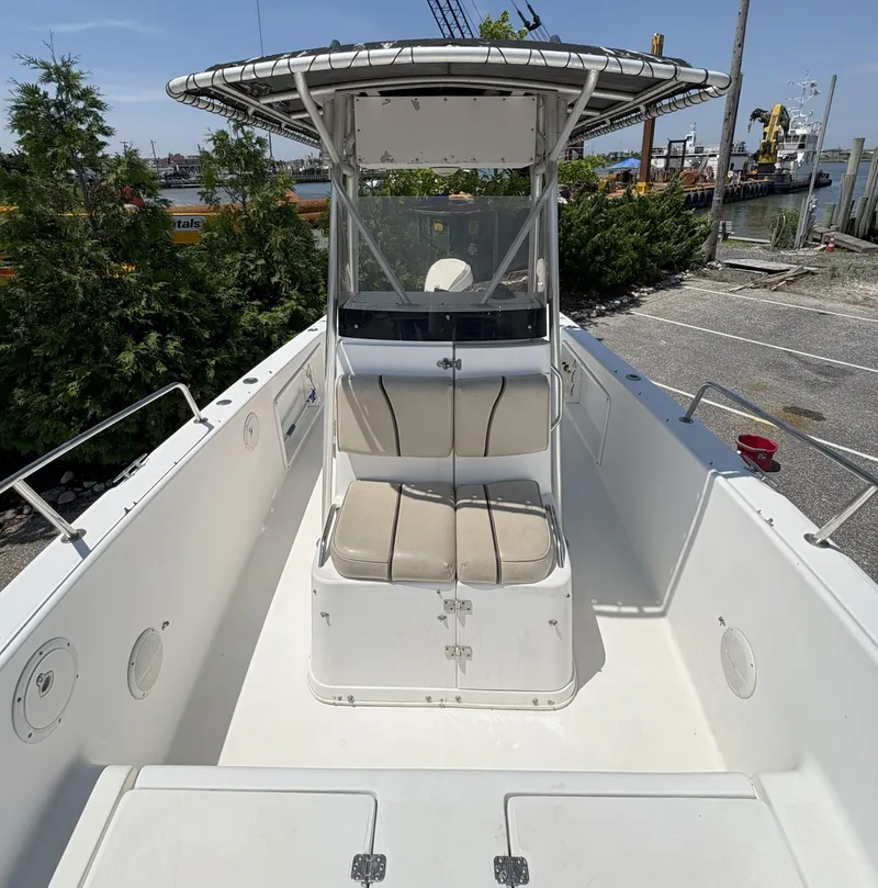 Slide: The Image of 1999 Century 2300 Center Console boat with seating, docked near greenery and industrial area. - 3