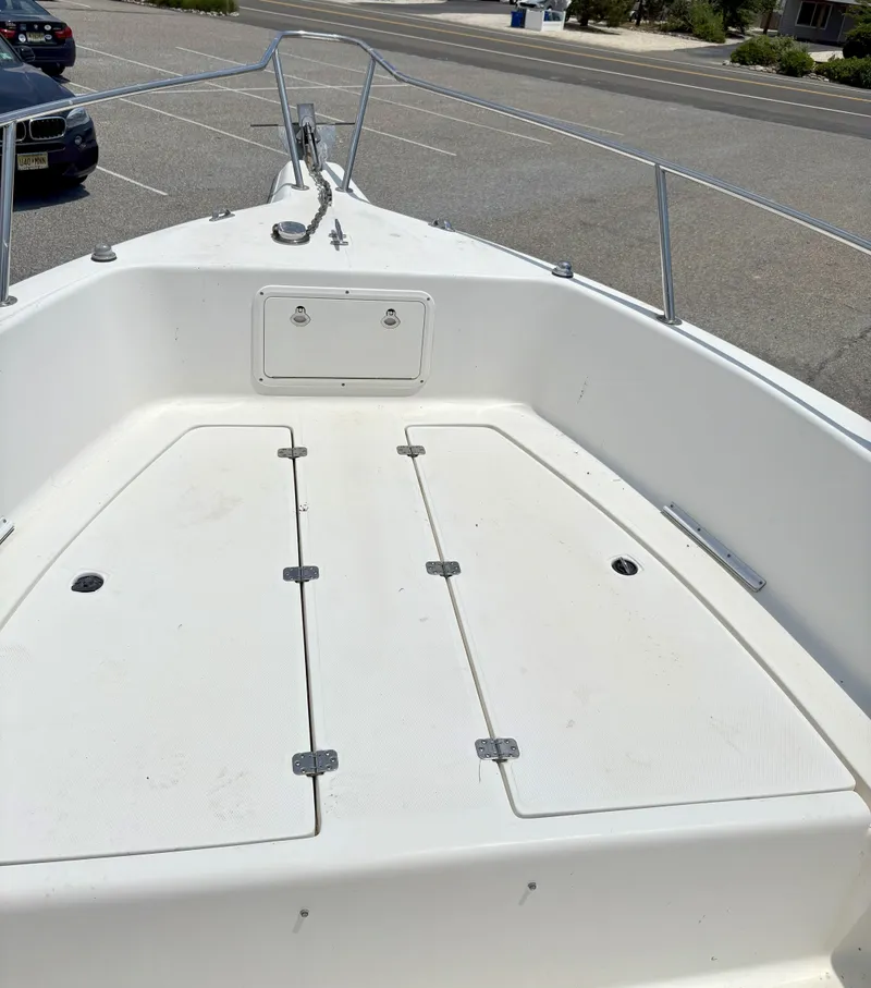 Slide: The Image of 1999 Century 2300 Center Console boat deck in a parking lot. - 4