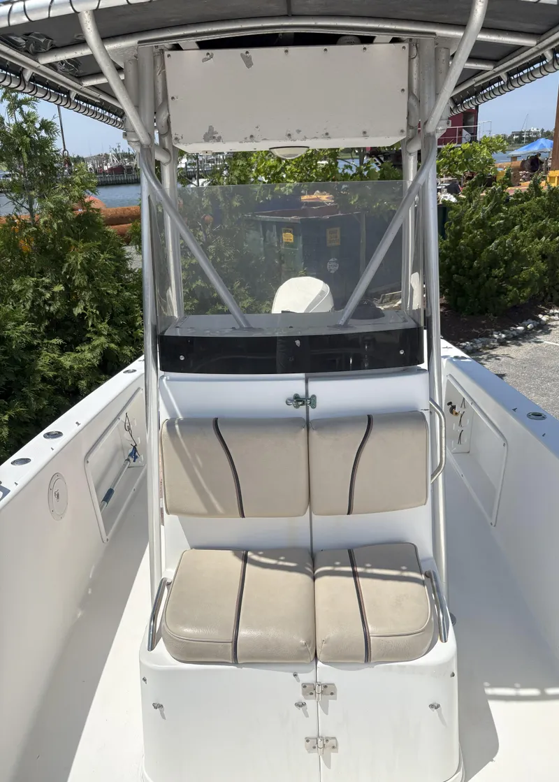 Slide: The Image of 1999 Century 2300 Center Console boat with dual seats and canopy, docked outdoors. - 8