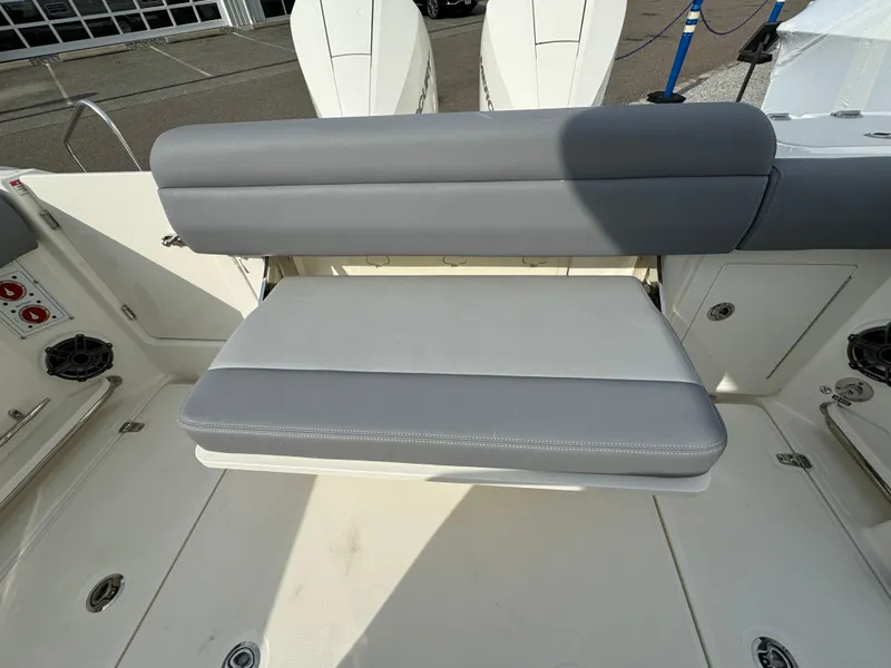 Slide: The Image of 2025 Boston Whaler 280 Outrage boat seat, gray and white upholstery, outdoor setting. - 11
