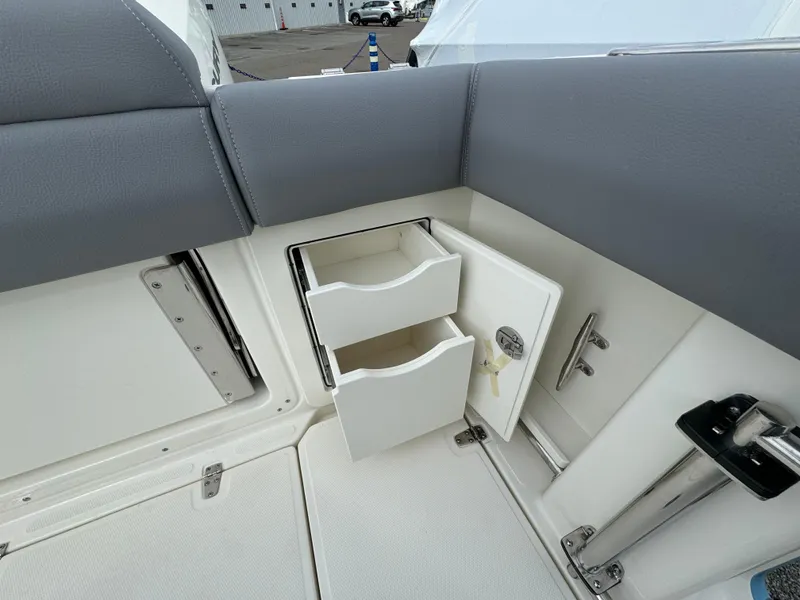 Slide: The Image of 2025 Boston Whaler 280 Outrage interior storage drawers and seating detail. - 13