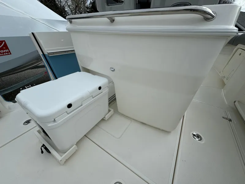 Slide: The Image of 2025 Boston Whaler 280 Outrage boat interior with cooler and seating area. - 15
