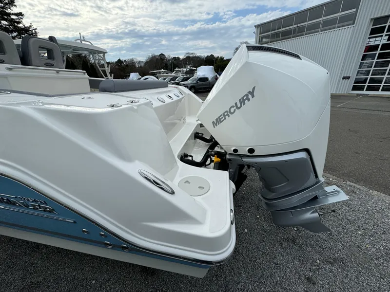 Slide: The Image of 2025 Boston Whaler 280 Outrage with Mercury outboard engine, docked outdoors. - 2
