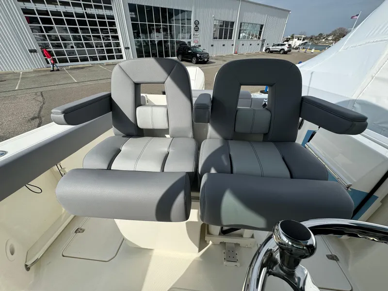 Slide: The Image of 2025 Boston Whaler 280 Outrage boat seats with gray upholstery and armrests. - 20