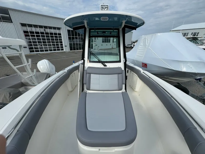 Slide: The Image of 2025 Boston Whaler 280 Outrage boat interior with seating, docked near a marina. - 27
