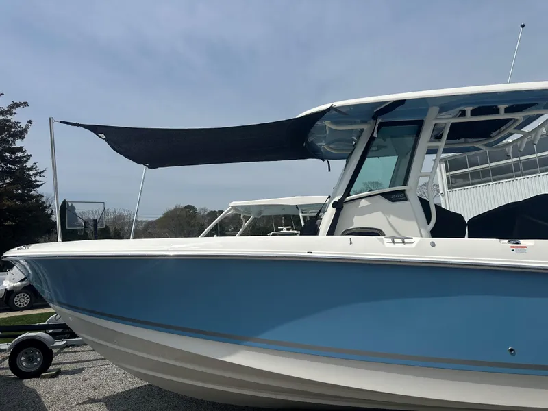 Slide: The Image of 2025 Boston Whaler 280 Outrage boat with blue hull and black canopy. - 33